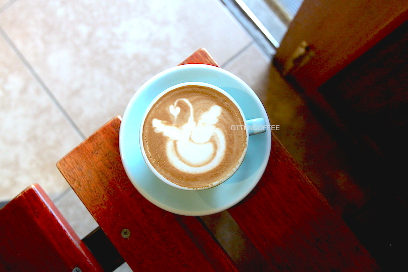 A cup of cappuccino with fancy art.